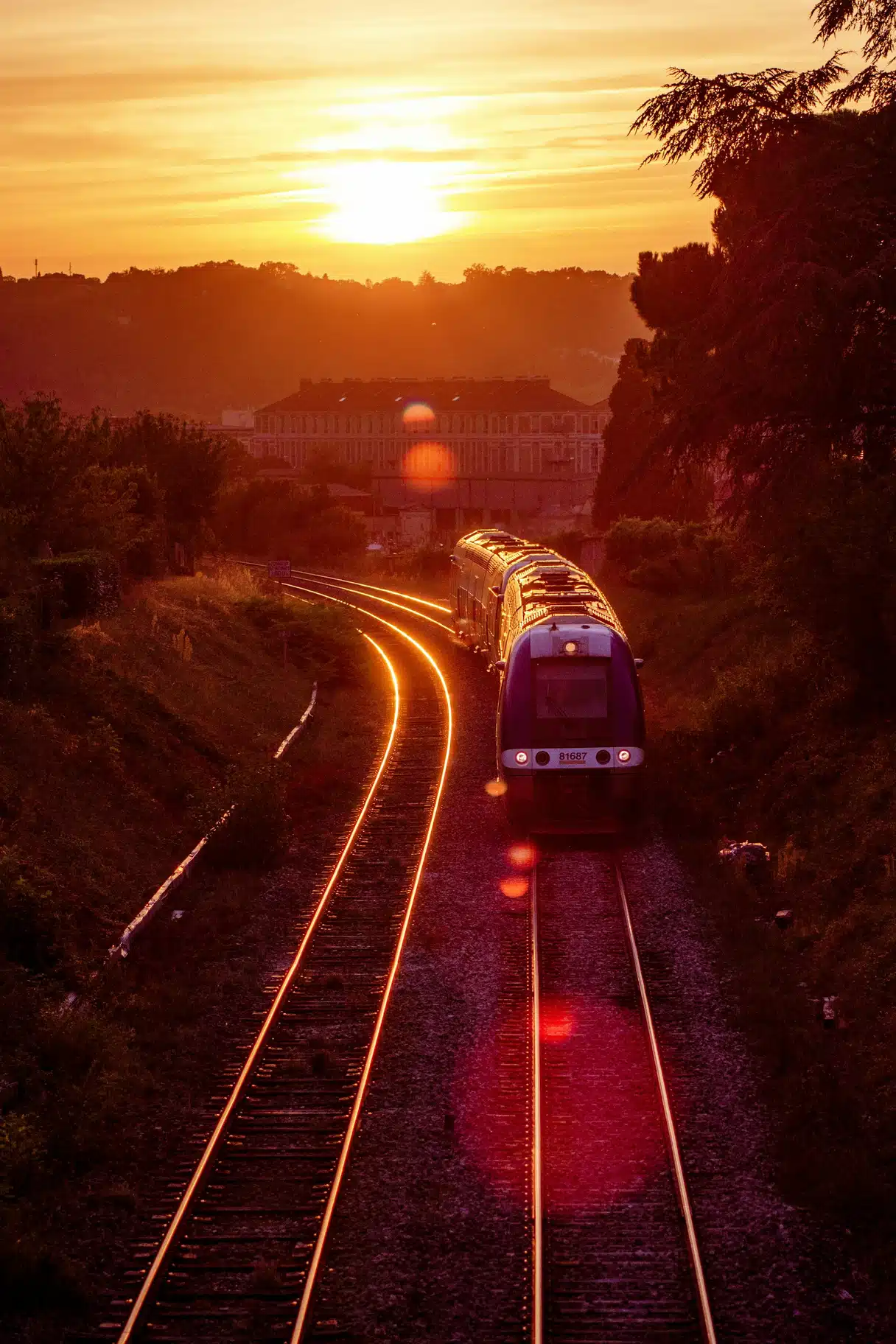 Un train TER en gare au soleil couchant